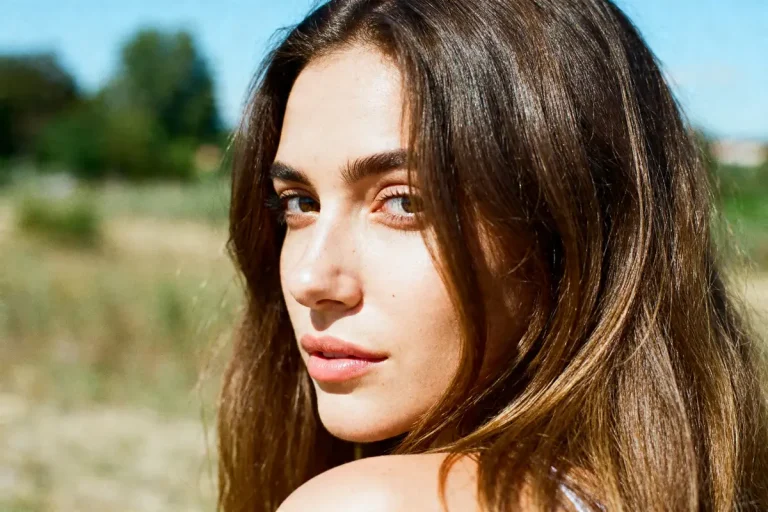 Jeune femme regardant arrière-plan flou, mettant en valeur ses cheveux de venus lumineux et naturels